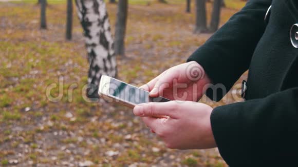 年轻女孩在城市公园用手机视频的预览图