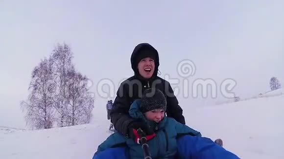 幸福的家庭骑行和微笑的雪管在雪道上视频的预览图