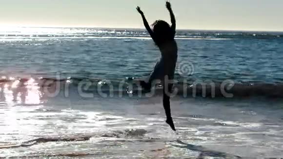 女人在海滩上跳跃视频的预览图