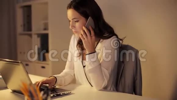 有笔记本电脑的女人在办公室打智能手机视频的预览图