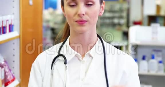 女药剂师在药房里拿着药盒视频的预览图