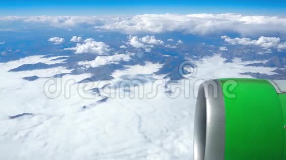 透过飞机窗飞机在云和山上空飞行的美丽景色视频的预览图
