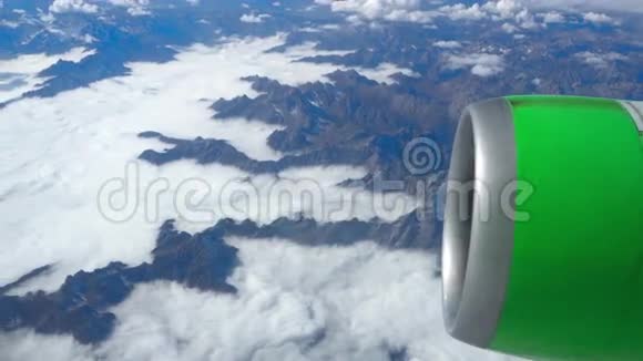 透过飞机窗飞机在云和山上空飞行的美丽景色视频的预览图