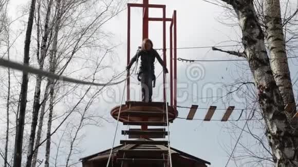 在极端公园的高绳道上年轻的女性登山者走在垂木桥旁视频的预览图