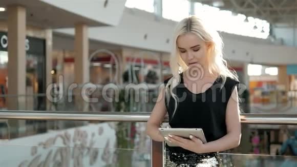 年轻的女乘客在机场等待航班时使用她的平板电脑美丽的女乘客在视频的预览图