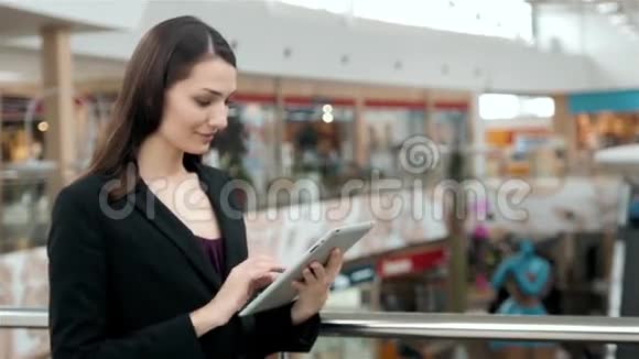 年轻的女旅客在机场等待航班时使用她的平板电脑商务女性之后视频的预览图