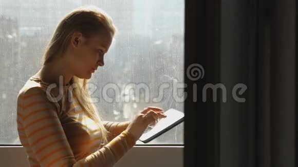 窗户边有笔记本电脑的女人视频的预览图