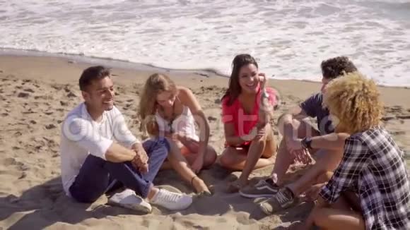 坐在海滩上的年轻人视频的预览图