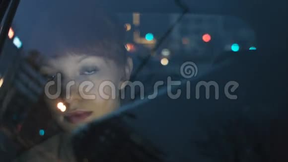 年轻的女商人透过窗户看视频的预览图