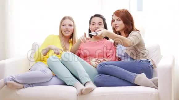 三个微笑的少女在家看电视视频的预览图