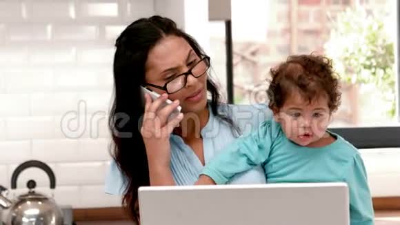 妈妈带着婴儿时用笔记本电脑视频的预览图