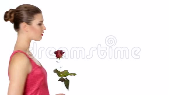 女人拿着红色的玫瑰在白色的背景上微笑视频的预览图