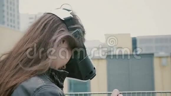 布吕内特的女孩子挥舞着头发在屋顶上使用虚拟现实眼镜4k视频的预览图