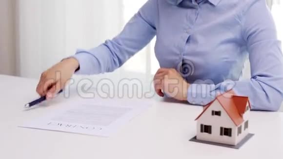 有房子模型和签字笔的女人视频的预览图