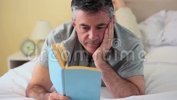 成熟的男人躺在床上看书视频的预览图
