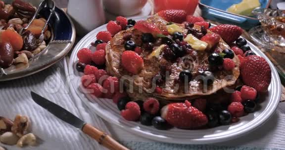 一份带浆果和干水果的煎饼早餐视频的预览图