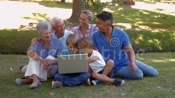 快乐的一家人一起在公园里用笔记本电脑视频的预览图