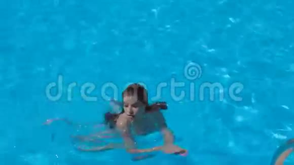 穿着白色比基尼在游泳池游泳的女孩视频的预览图