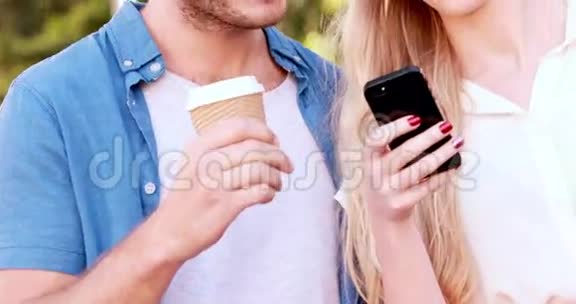 微笑的臀部夫妇使用智能手机视频的预览图