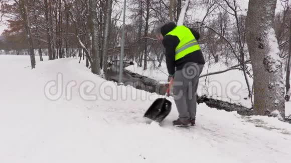 看门人在冬天从雪地里清理人行道视频的预览图