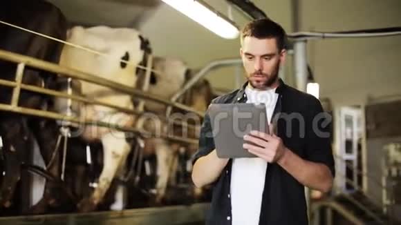 有平板电脑和奶牛场的年轻人视频的预览图