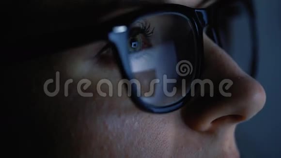 戴眼镜的女人看着监视器上网视频的预览图