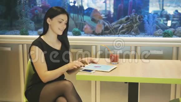 坐在咖啡馆喝果汁的女孩视频的预览图