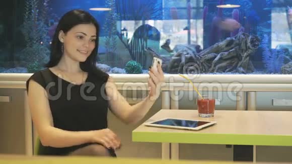 坐在咖啡馆喝果汁的女孩视频的预览图