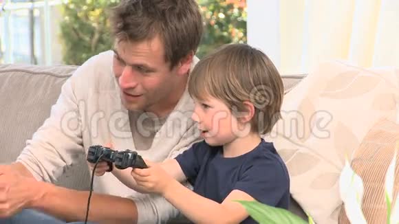 儿子和爸爸在玩电子游戏视频的预览图