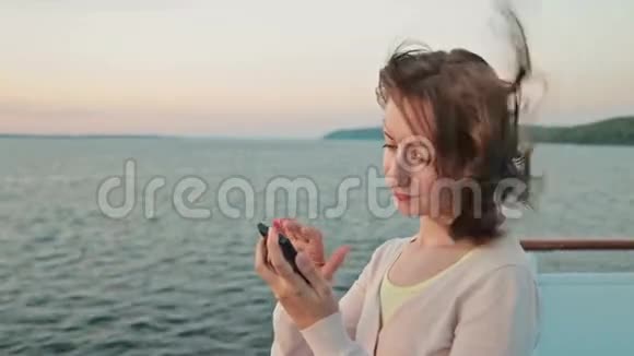 在游轮上用手机的女人视频的预览图