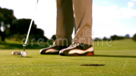 高尔夫球手把球放在绿色上视频的预览图