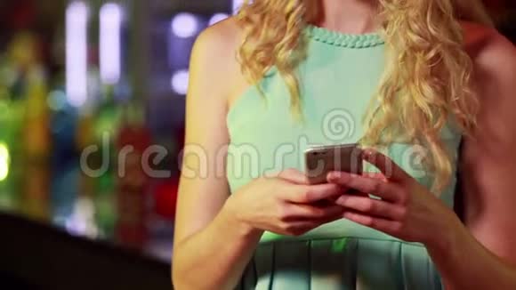 微笑的女人在酒吧发短信视频的预览图