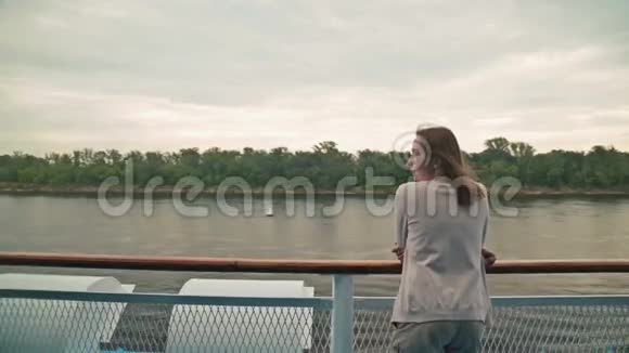 年轻漂亮的女人站在游轮甲板上看着河视频的预览图