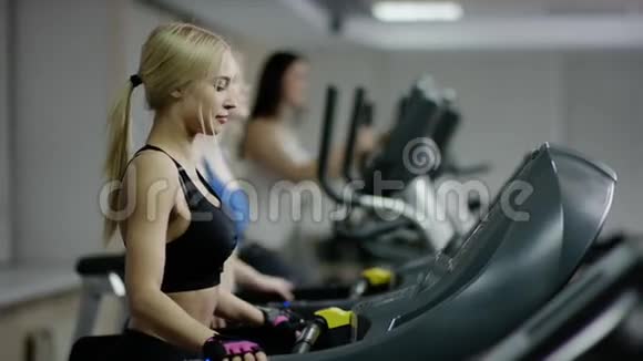 在跑步机上行走的漂亮年轻女人视频的预览图