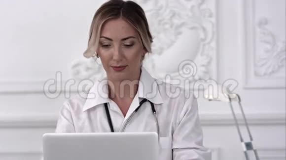 女医生坐在桌子上在医院里用笔记本电脑视频的预览图