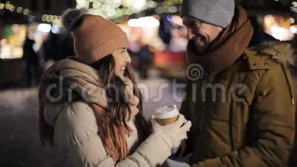 圣诞市场上有咖啡的快乐情侣视频的预览图