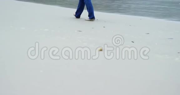 高级妇女在海滩散步的后景视频的预览图