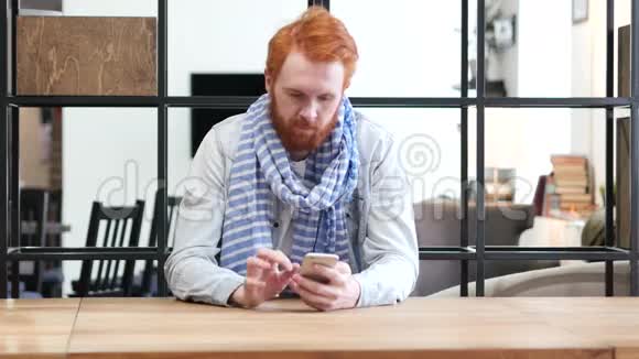 男子浏览智能手机坐在办公室视频的预览图