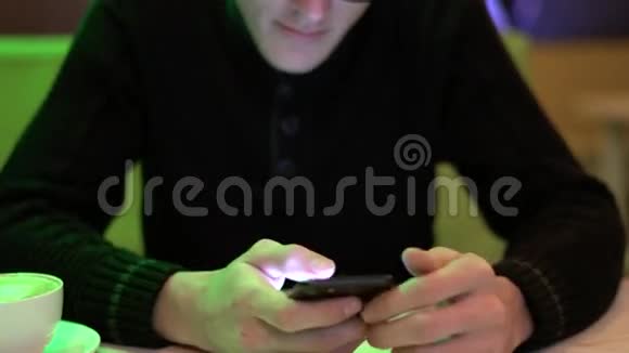 在咖啡馆里用智能手机的年轻人视频的预览图