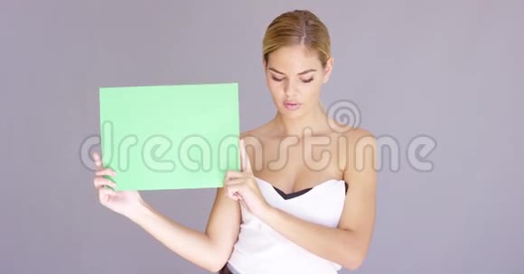 一个漂亮的年轻姑娘带着空白的牌子视频的预览图