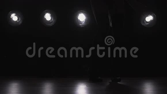 一个女孩在背景灯上跳舞的剪影慢动作视频的预览图