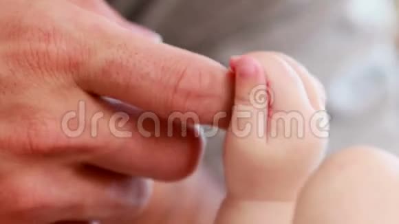 成人手牵着婴儿的手视频的预览图