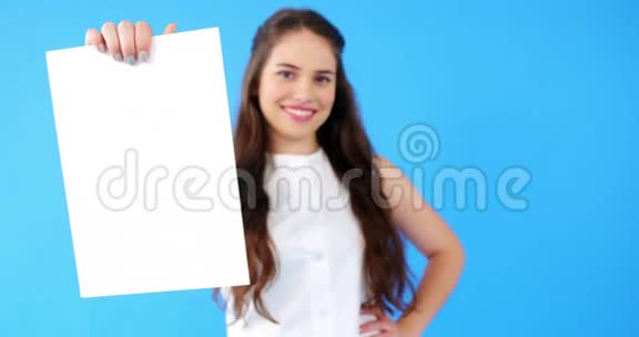 一位美丽的女士手里拿着蓝色背景的空白标语牌视频的预览图