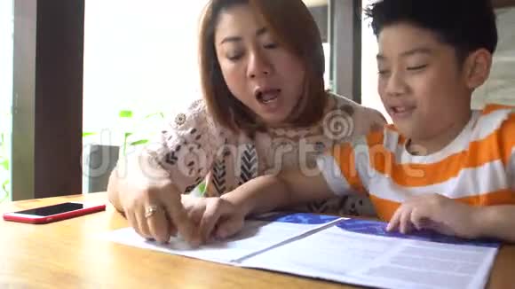 快乐的亚洲家庭男孩和父母一起读书视频的预览图