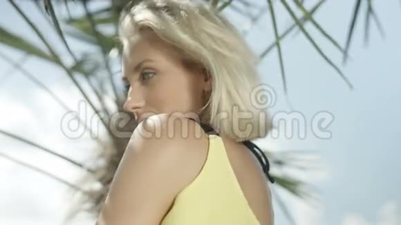 金发女孩在热带海滩上摆姿势视频的预览图