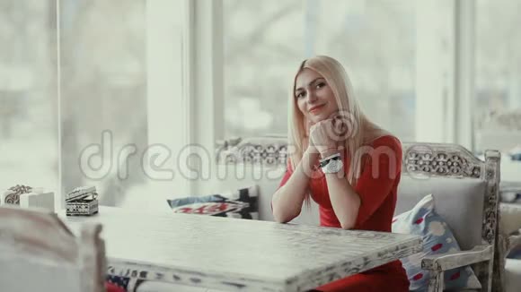 漂亮的年轻女子坐在窗边视频的预览图