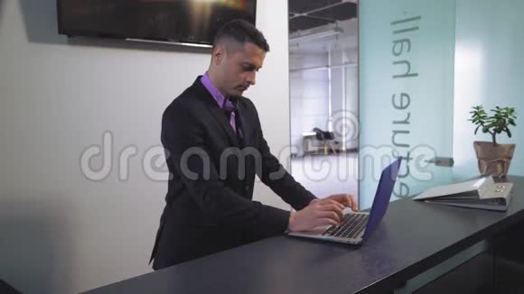 英俊的商人在笔记本电脑上打字视频的预览图