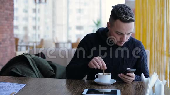 帅哥在咖啡馆的智能手机上发短信视频的预览图