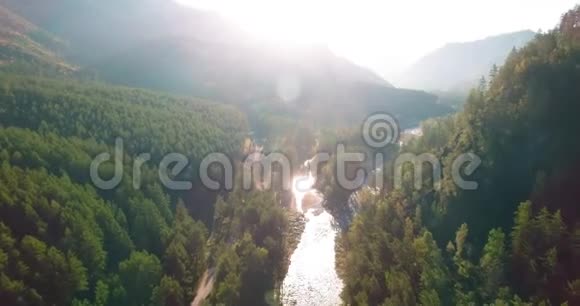 在阳光明媚的夏日早晨中气飞越新鲜的山河和草地农村土路下面视频的预览图