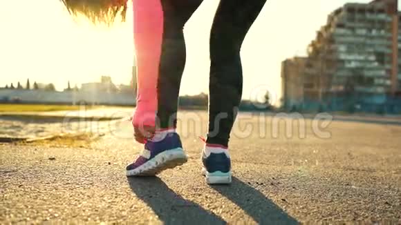 跑鞋女人系鞋带到户外跑步视频的预览图